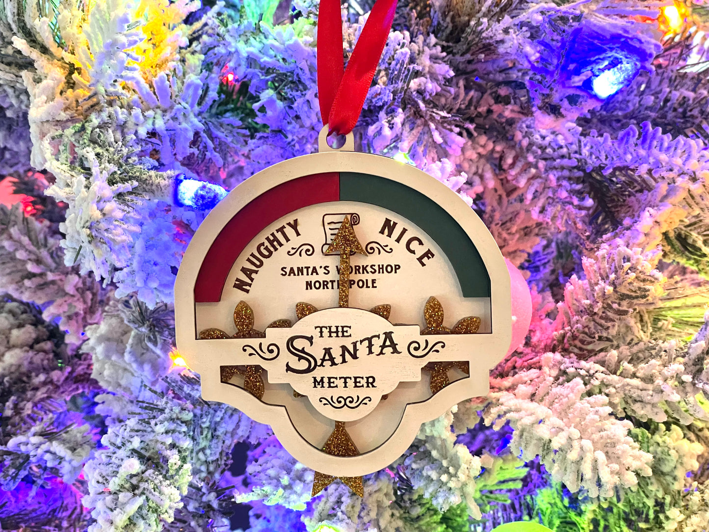 Santa Meter hanging on Christmas tree. The meter has a naughty and nice section, with movable acrylic arrow to point to either section.