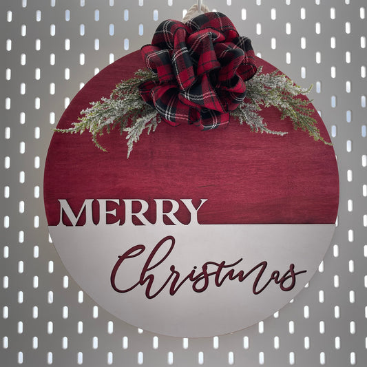 15" round sign that says Merry Christmas with a plaid handmade bow on top. Edit alt text